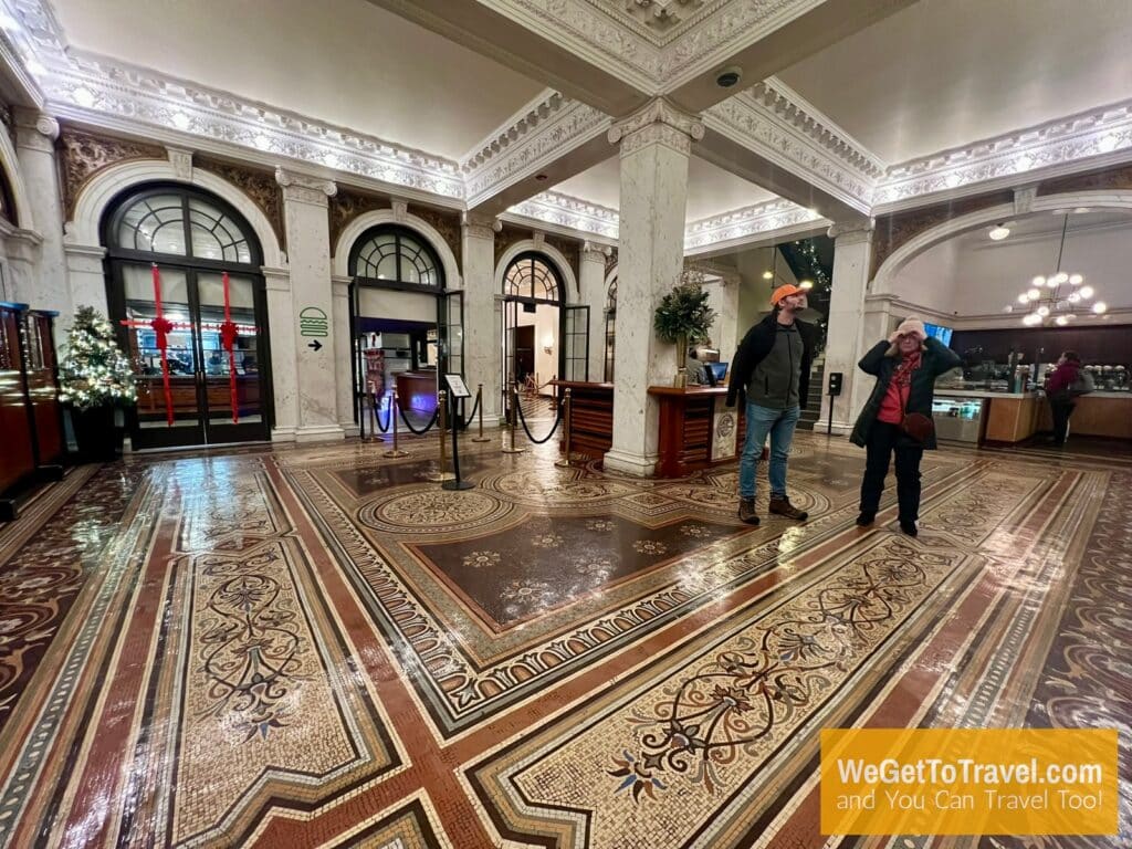 Trent and Sandra stand on the antique, hand laid tile floor at the Chicago Athletic Association hotel