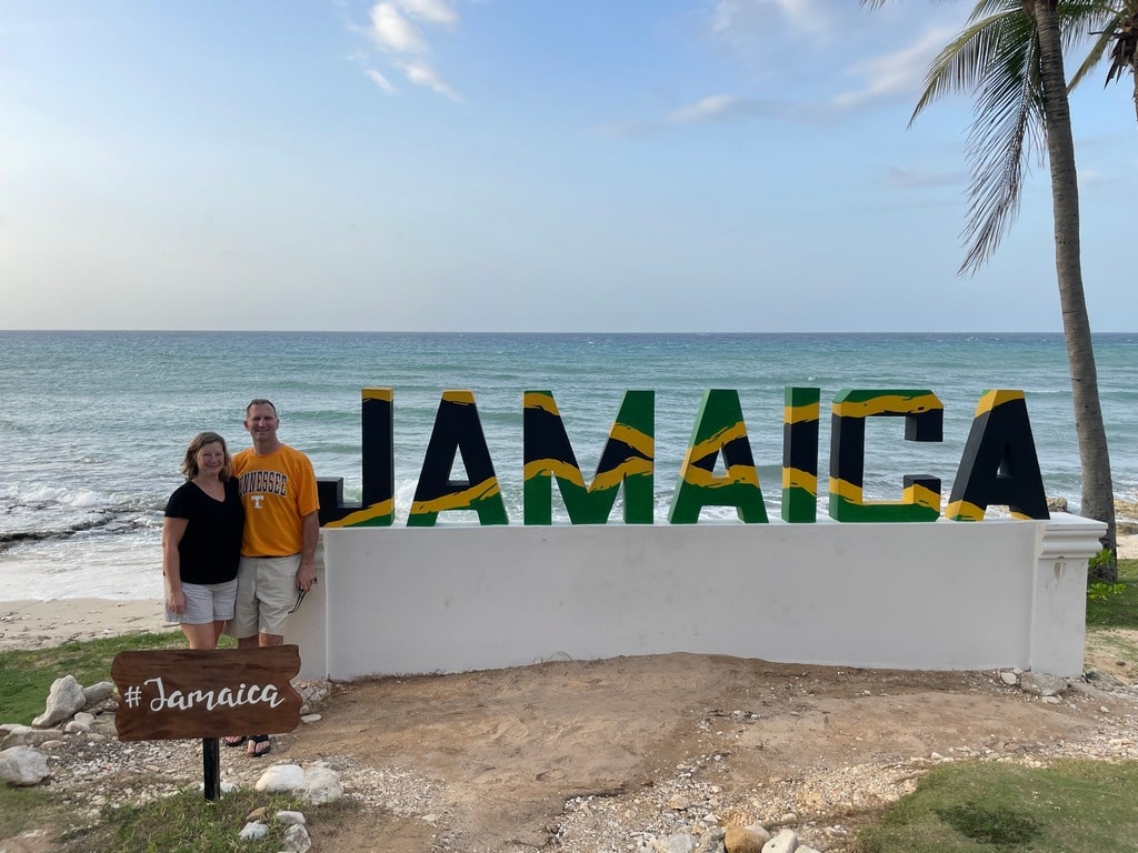 Ross & Zuzu in front of big Jamaica sign on the beach