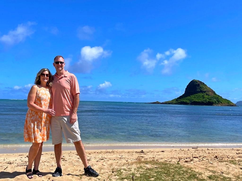 Ross and Zuzu in resort wear on Hawaiian beach with island in the background