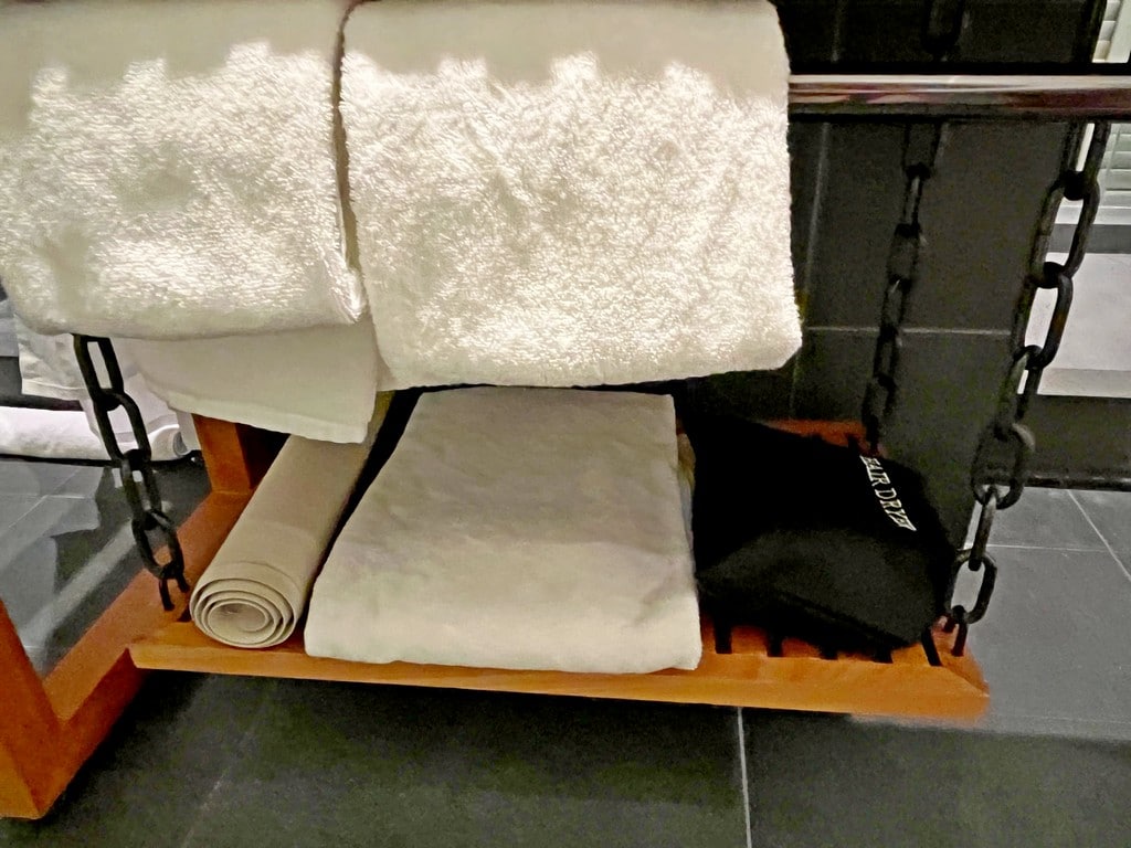 towels, hair dryer and bath mat under the bathroom sink