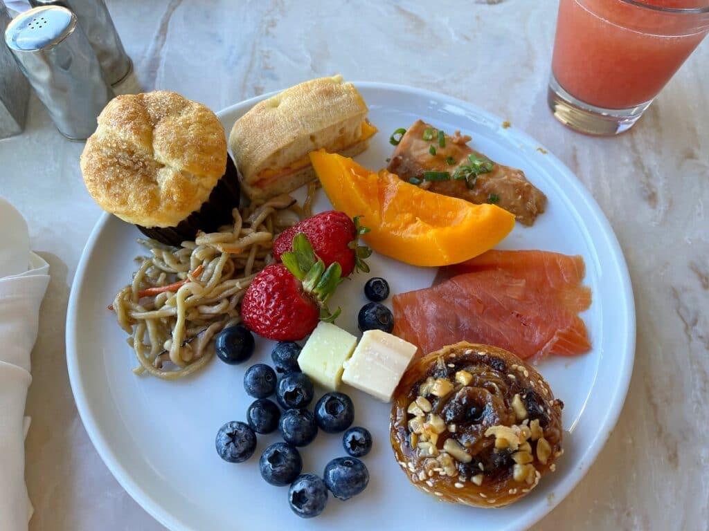breakfast plate with blueberries, strawberries, smoked salmon, cheese cubes, noodles, and a fantastic pastry at andaz maui