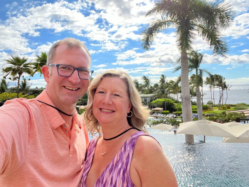 Ross and Sandra smiling in front of the Andaz Maui pools