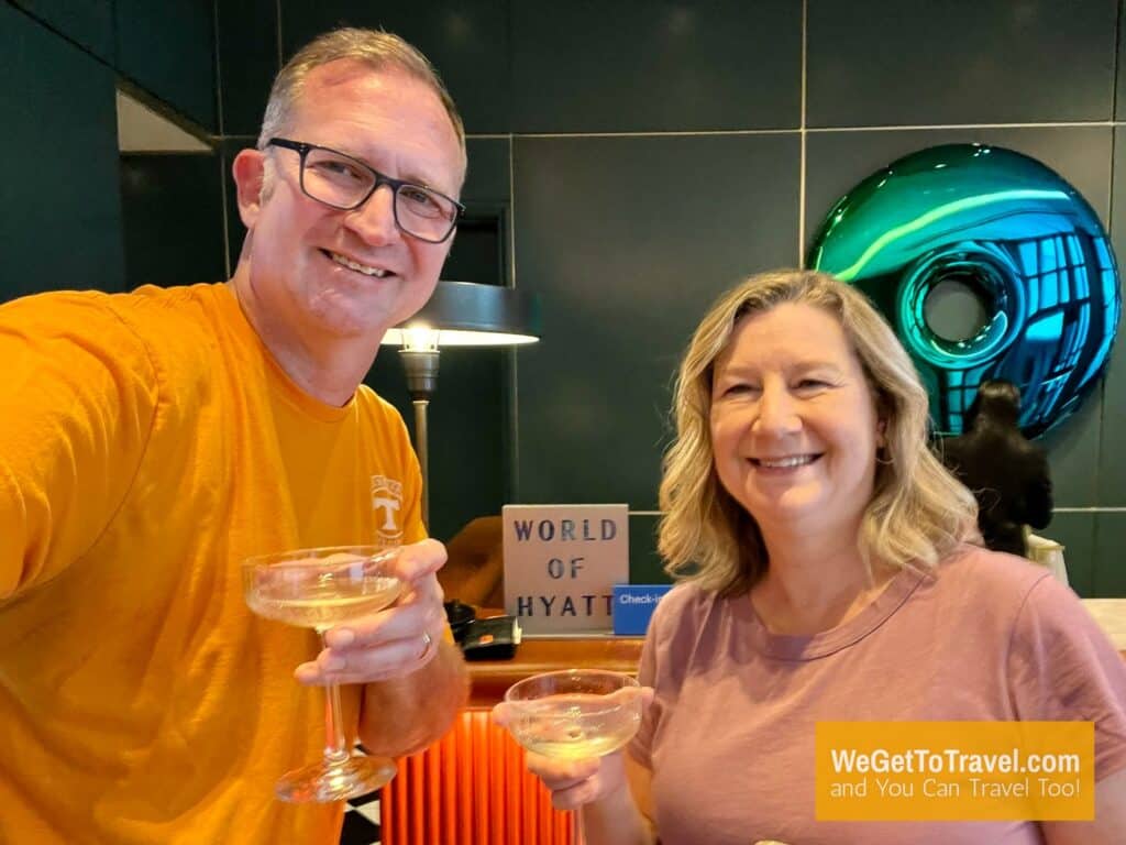 Ross and Zuzu with welcome champagne toast at Dream Nashville World of Hyatt check in line