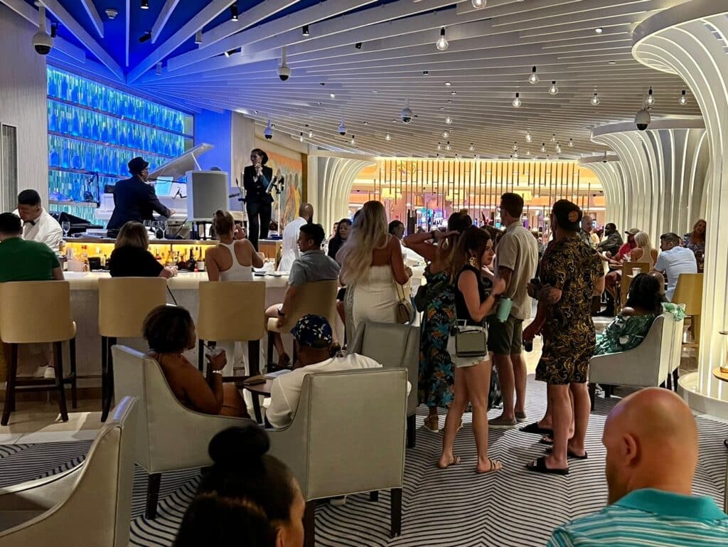Resort guests standing at sitting around a band stage at Jazz Bar inside Grand Hyatt Baha Mar.