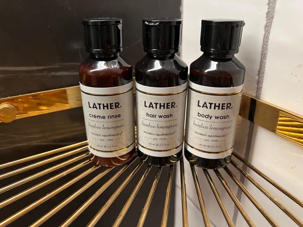 Bathroom shampoo, conditioner and shower gel by Lather brand.