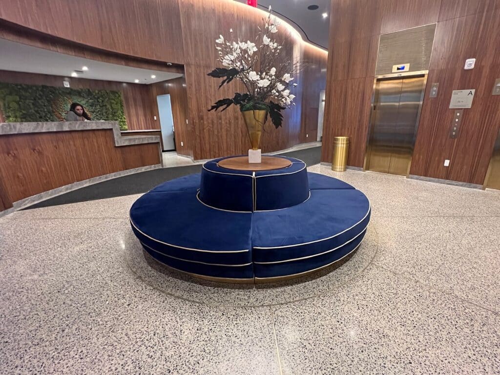 Front desk and a blue circular couch in the Grayson Hotel lobby.