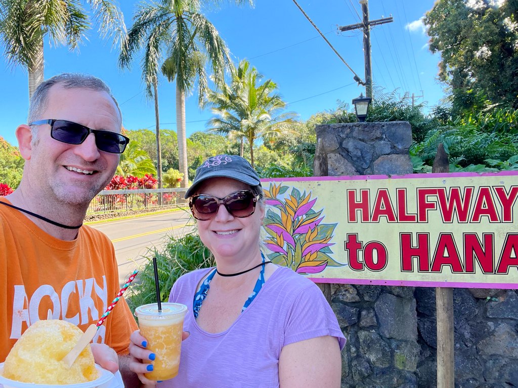 smiling in front of Halfway to Hana sign