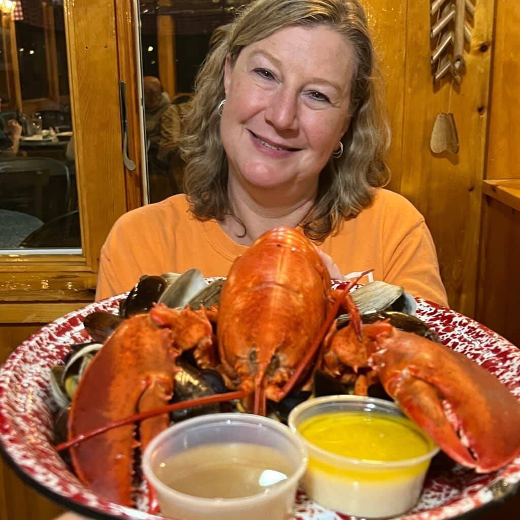 Zuzu with a huge lobster on a platter.