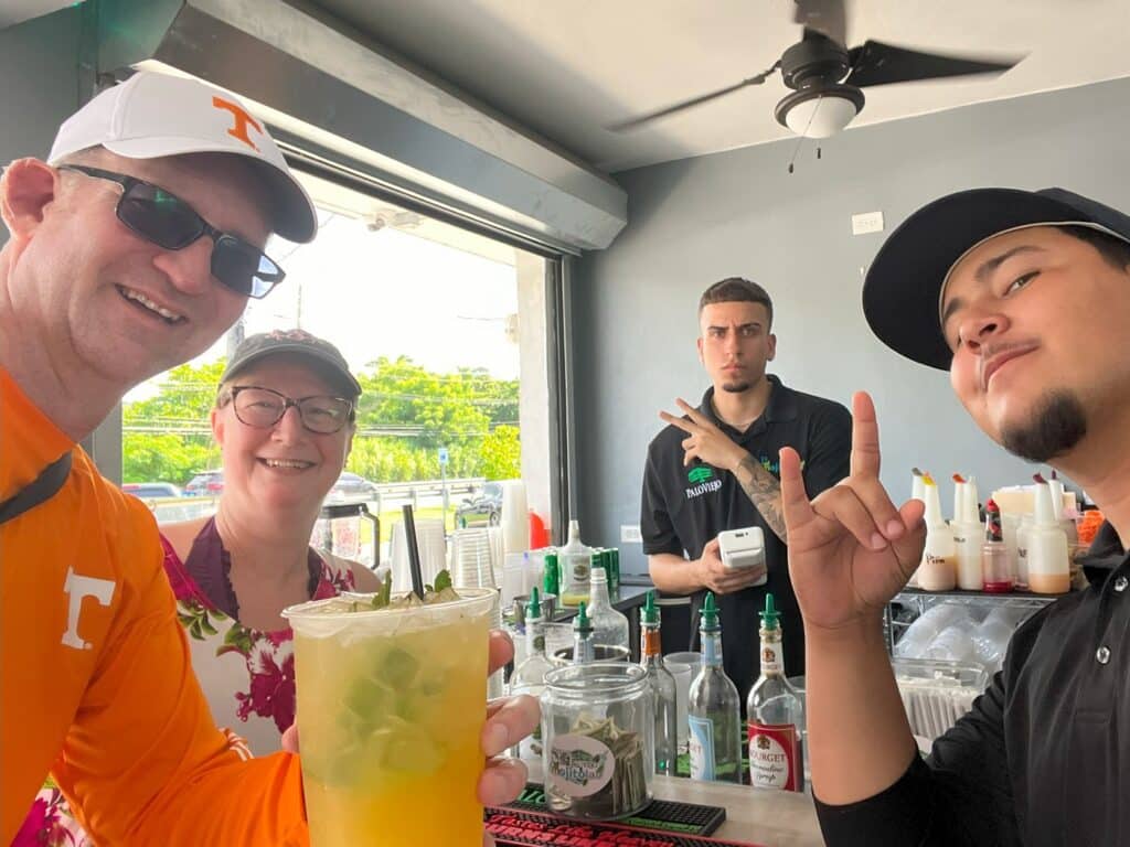Ross and Zuzu holding large mango mojito with 2 bartenders at Mojito labs in Puerto Rico