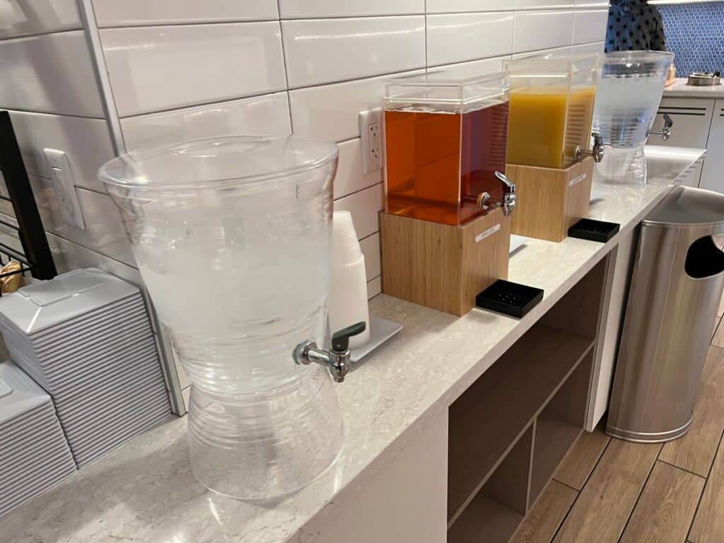 water, apple juice & pineapple juice dispensers on the Hyatt PCB breakfast bar.