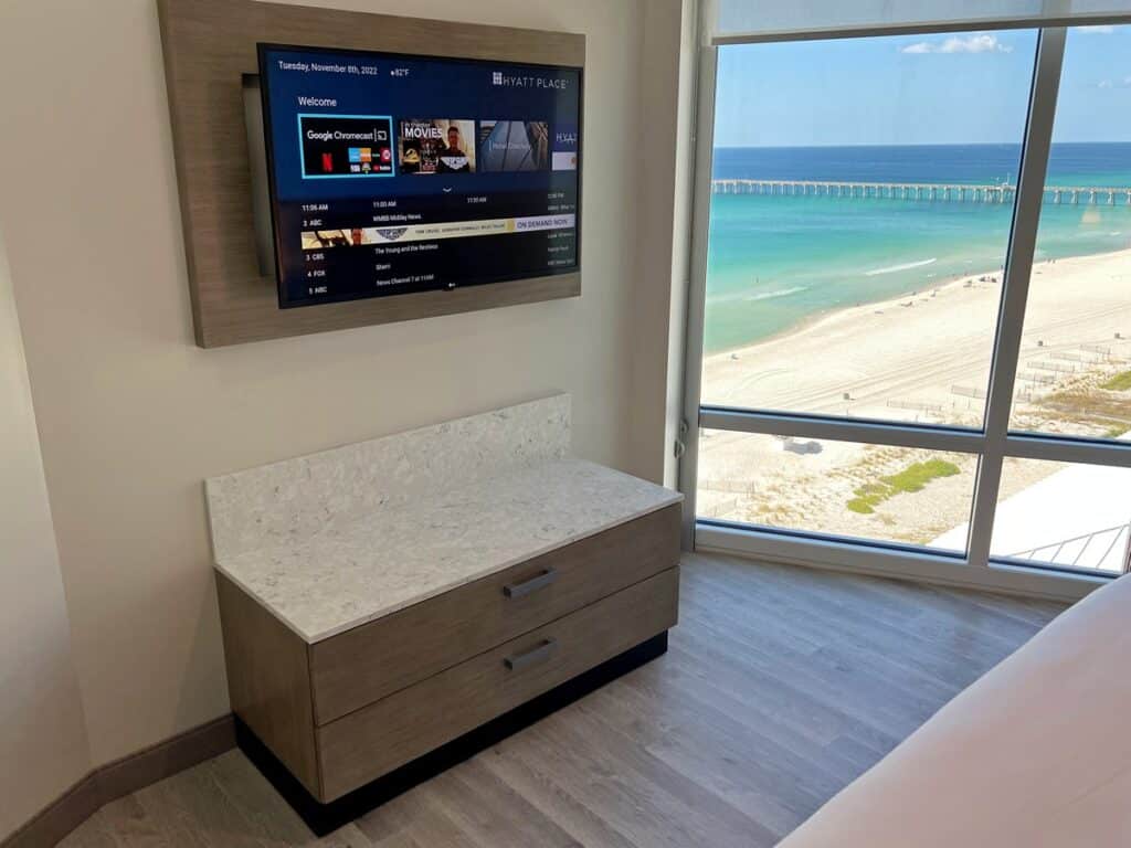 TV, dresser and window with view of the beach from the Hyatt PCB suite.