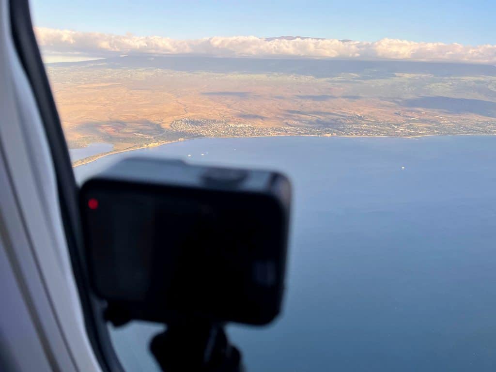 Picture of GoPro camera in airplane window above Maui in Hawaii