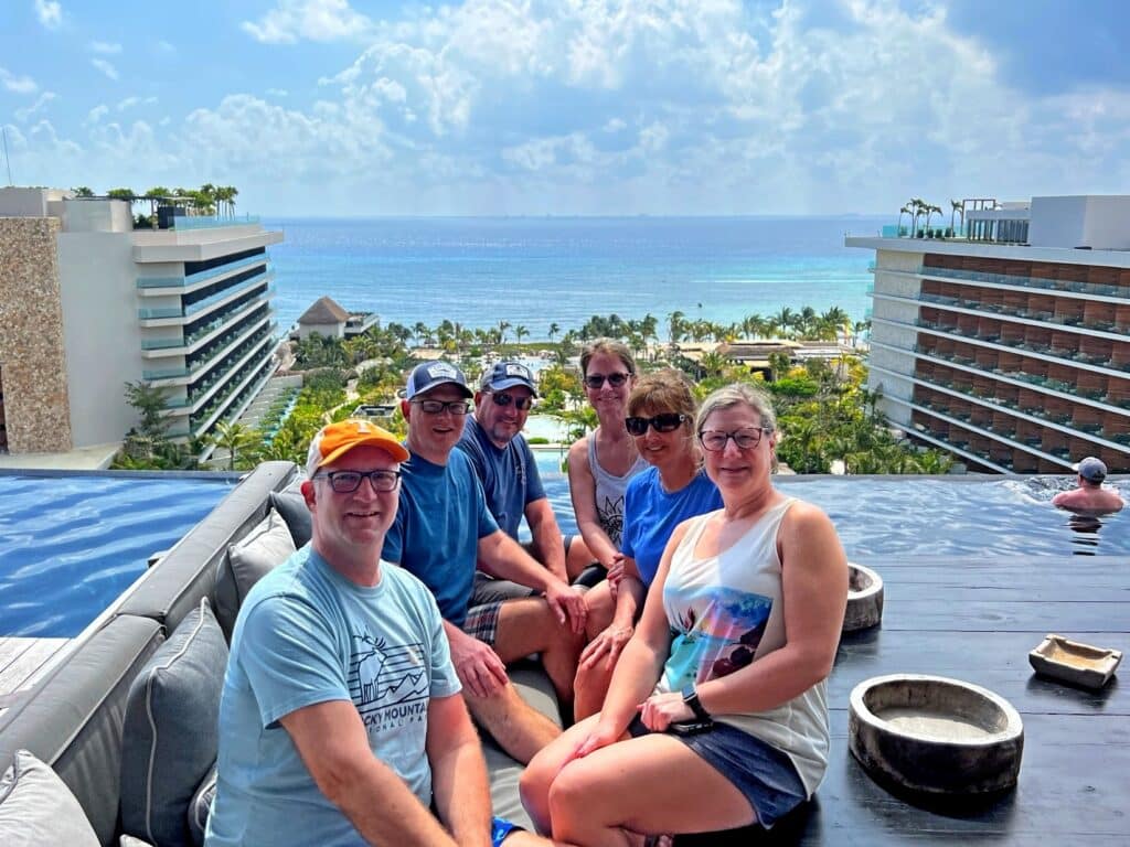 3 couples at the Secrets Moxche  Preferred Club rooftop pool smiling because this trip was free on credit card points