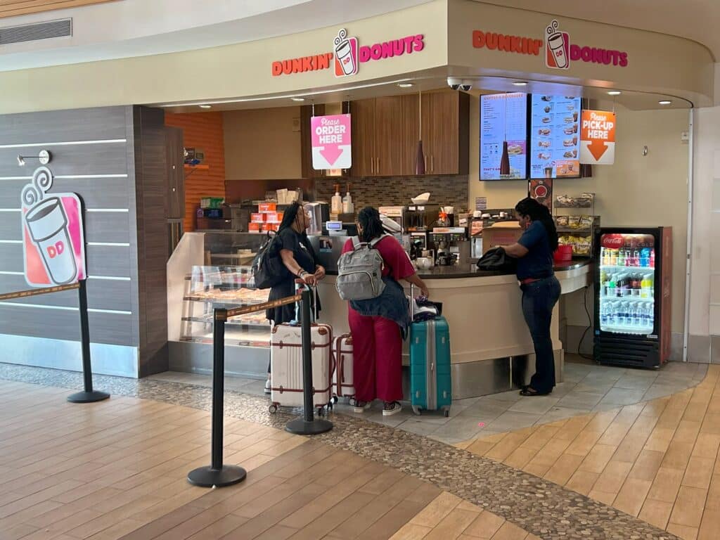 people in line at Dunkin Donuts in Nassau Airport Arrivals area