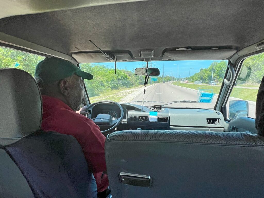 view of our taxi and driver from the backseat as we travel from Baha Mar to Nassau Airport