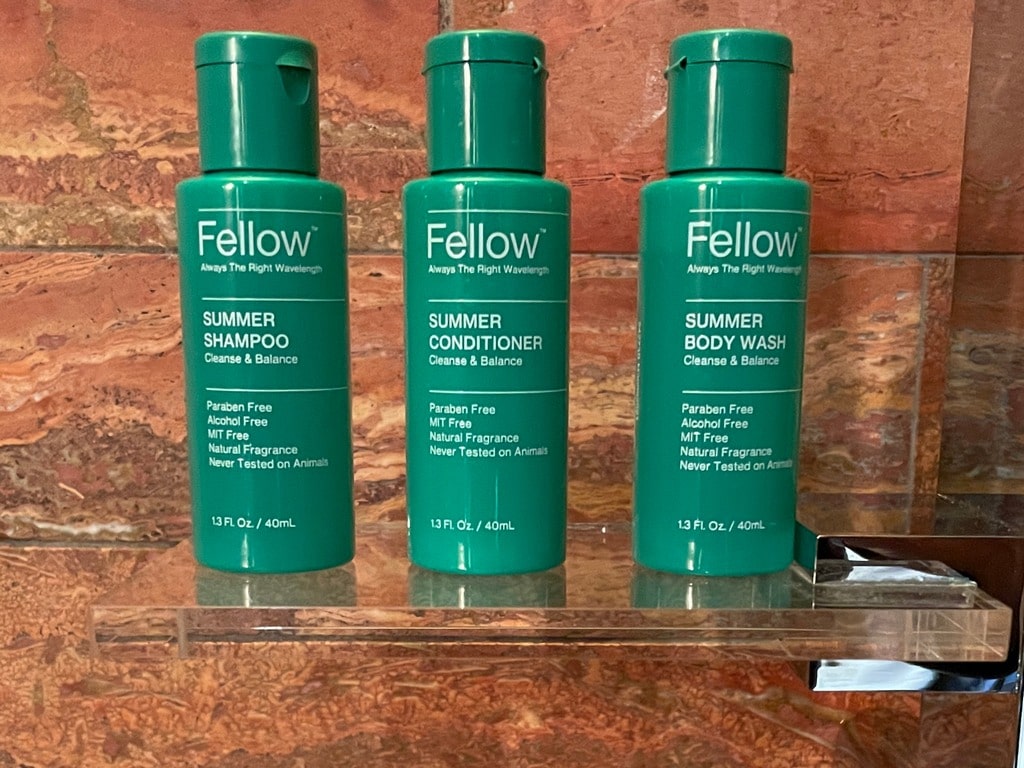 green Fellow brand shampoo, conditioner and body wash small bottles in hotel bathroom