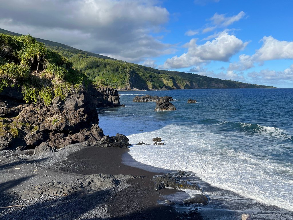 waves crashing onto black sand beach near Hana, Maui, Hawaii