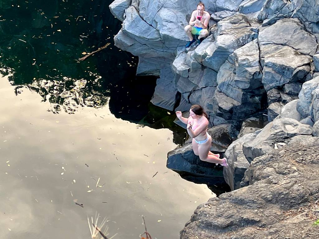 Girl Cliff diving at Venus Pools on Road to Hana