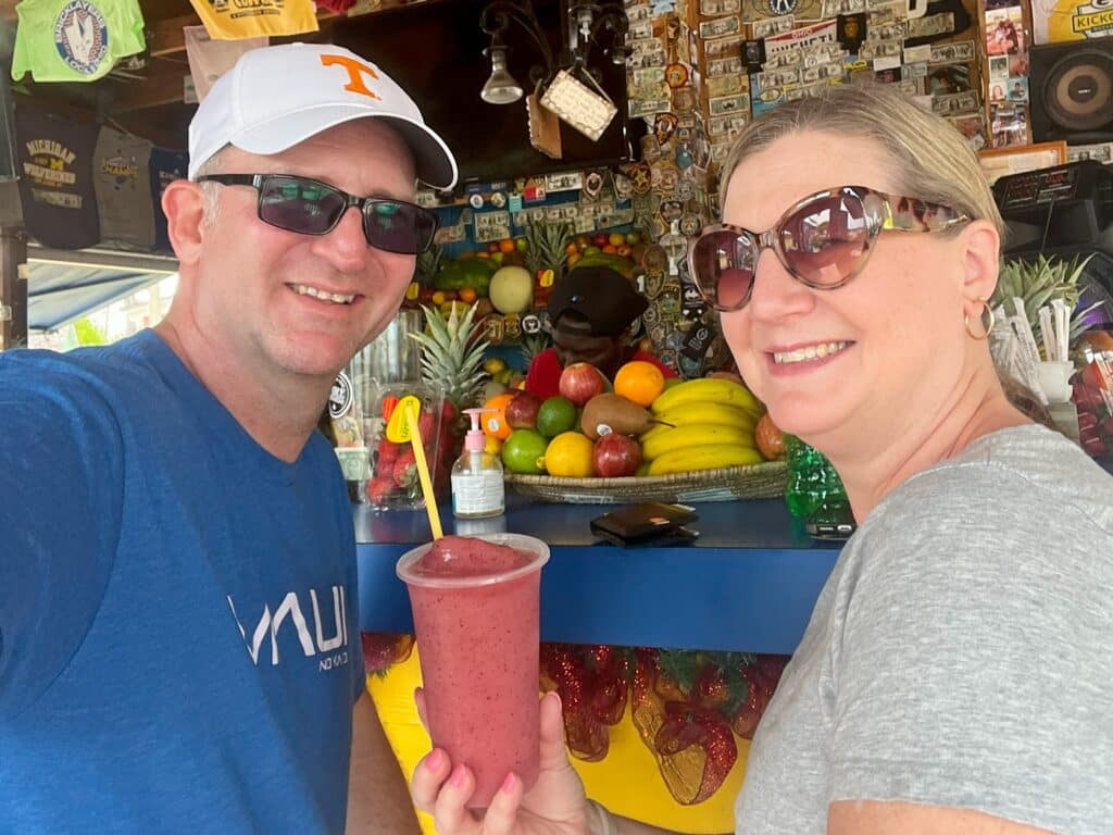 Ross and Zuzu holding Strawberry Daiquiri at beach bar in Nassau