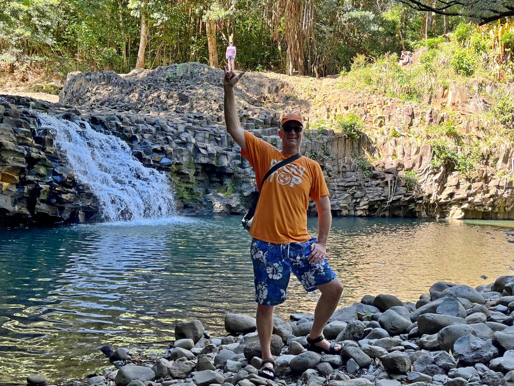 Wearing an orange Rocky Top shirt in front of waterfall in Hawaii