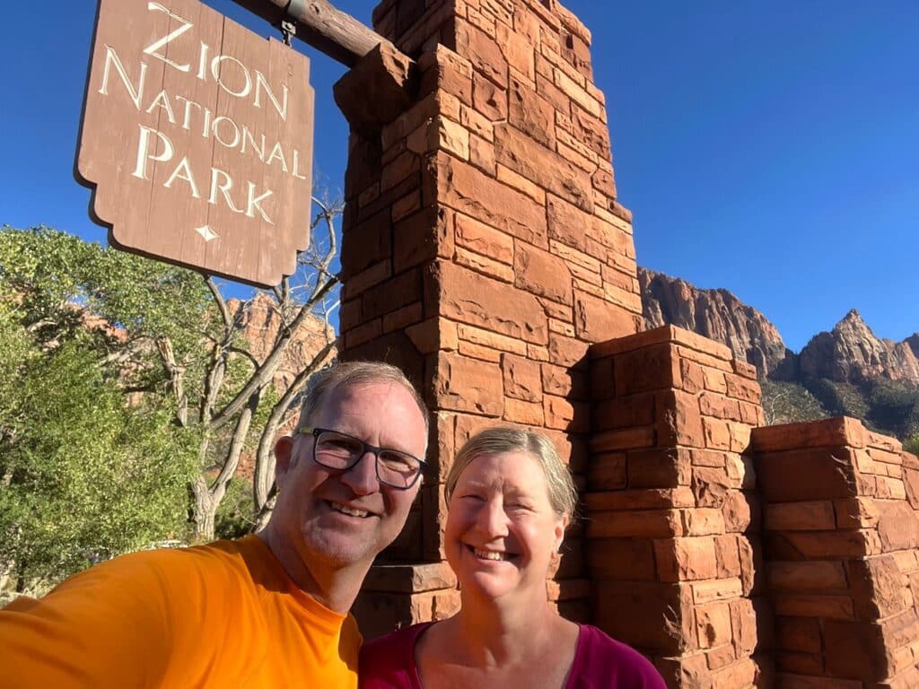 Ross and Zuzu in front of Zion National Park sign
