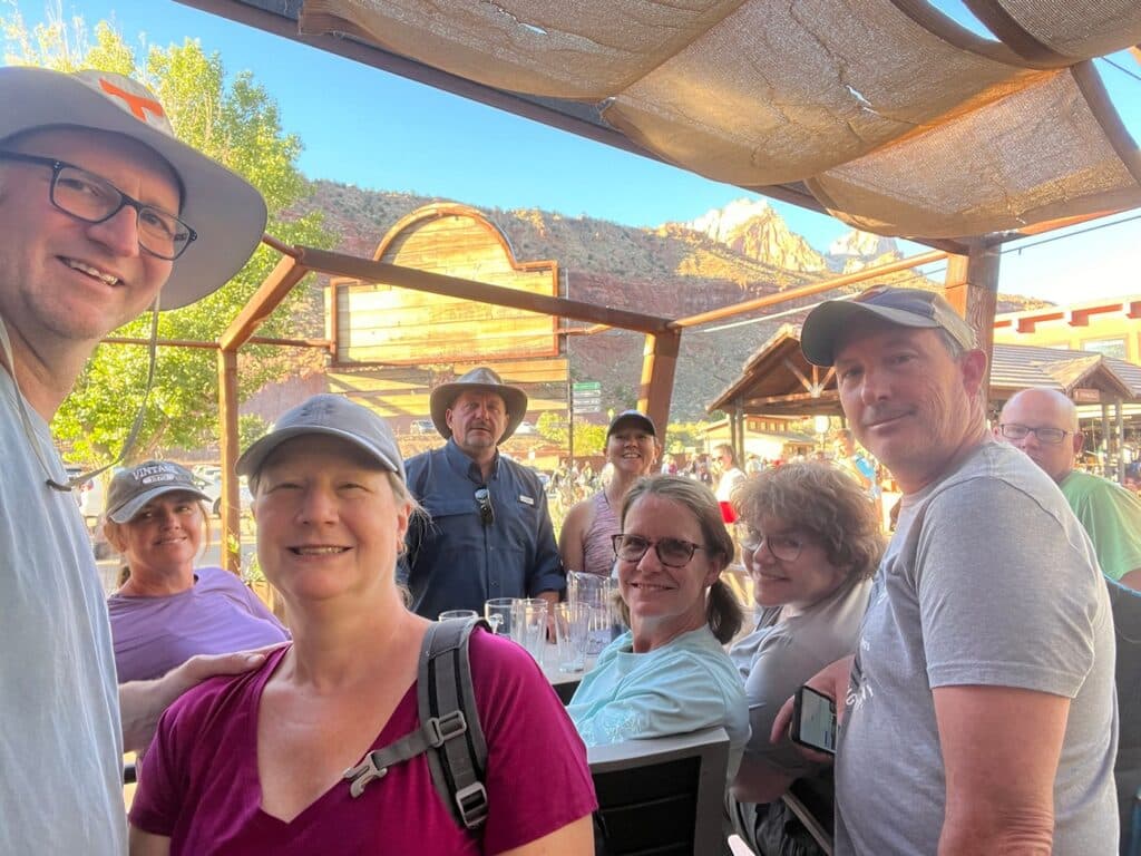 Travel friends sharing a beer after hiking the Narrows in Zion National Park