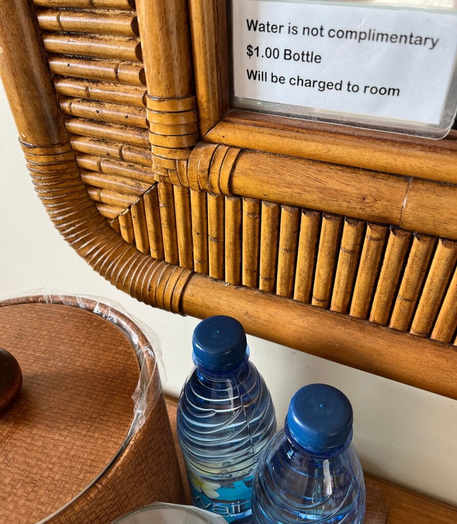 Sign for water bottles says "water is not complimentary, $1 Bottle will be charged to room"
