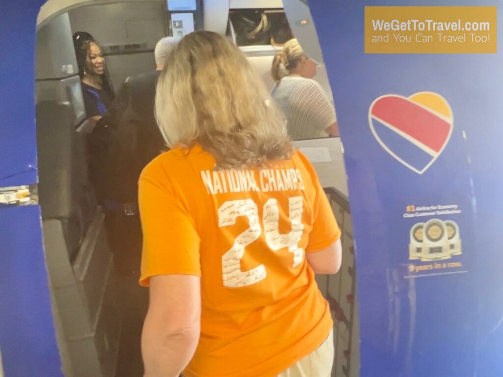 Sandra boarding a Southwest flight that was free with her Companion Pass while waring her orange 2024 National Champs shirt